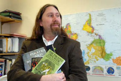 
Ian Chambers, a history professor at the University of Idaho, holds some of his resource material in his office  Monday. He will teach a one-semester class about pirates starting in January. His expertise is in colonial America. 
 (Jesse Tinsley / The Spokesman-Review)