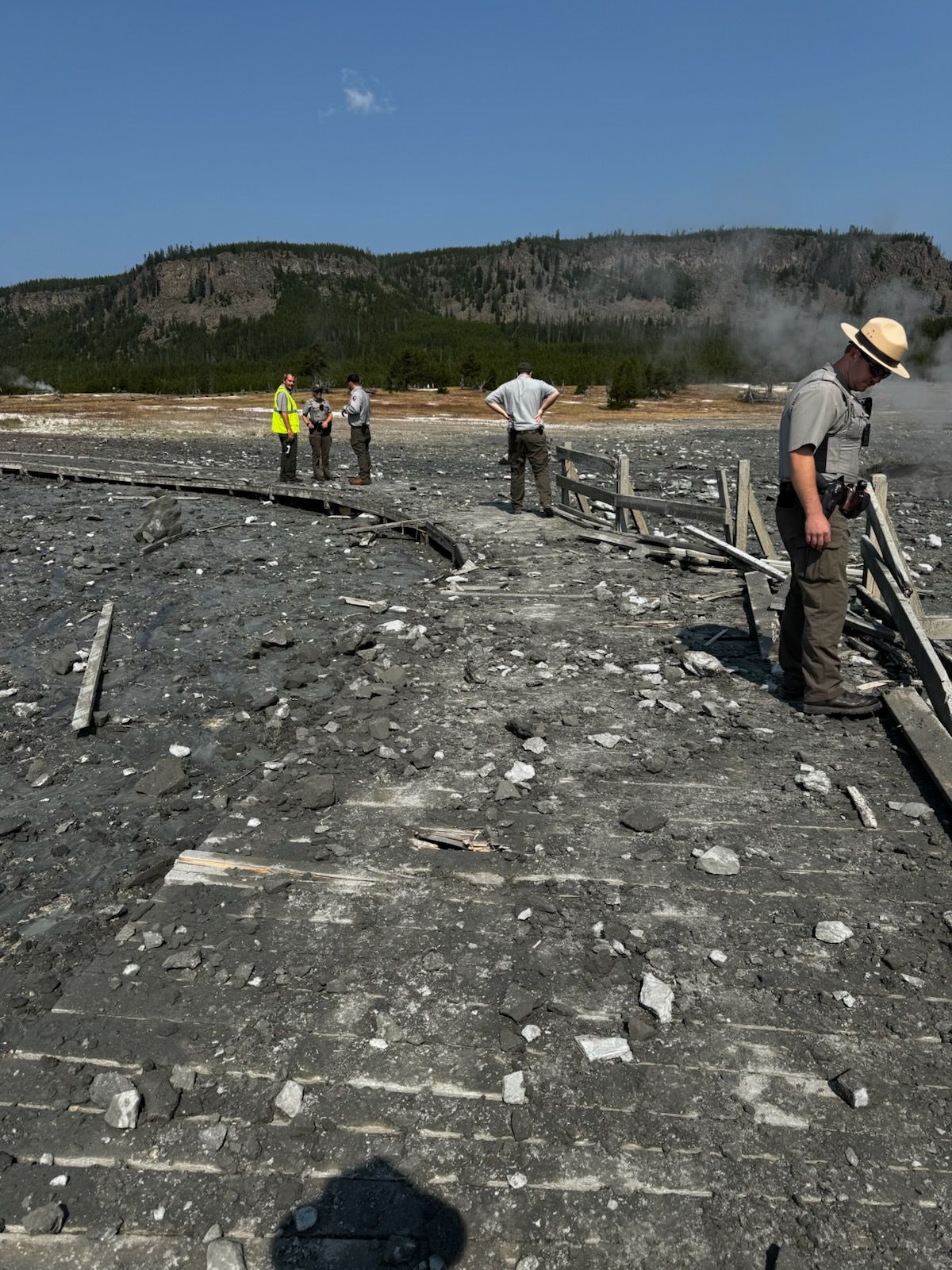 Yellowstone officials investigate the damage along the Biscuit Basin boardwalk on July 23 following a hydrothermal explosion.  (Courtesy of Yellowstone National Park )