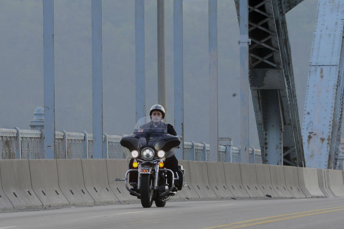 Father Lou Vallone, pastor of St. John of God Parish in McKees Rocks, Pa., crosses the McKees Rocks bridge on his Harley Davidson.