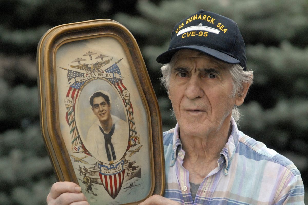 Ernest Peluso holds a colorized photograph of himself taken just before he got out of the Navy in 1945. (File)
