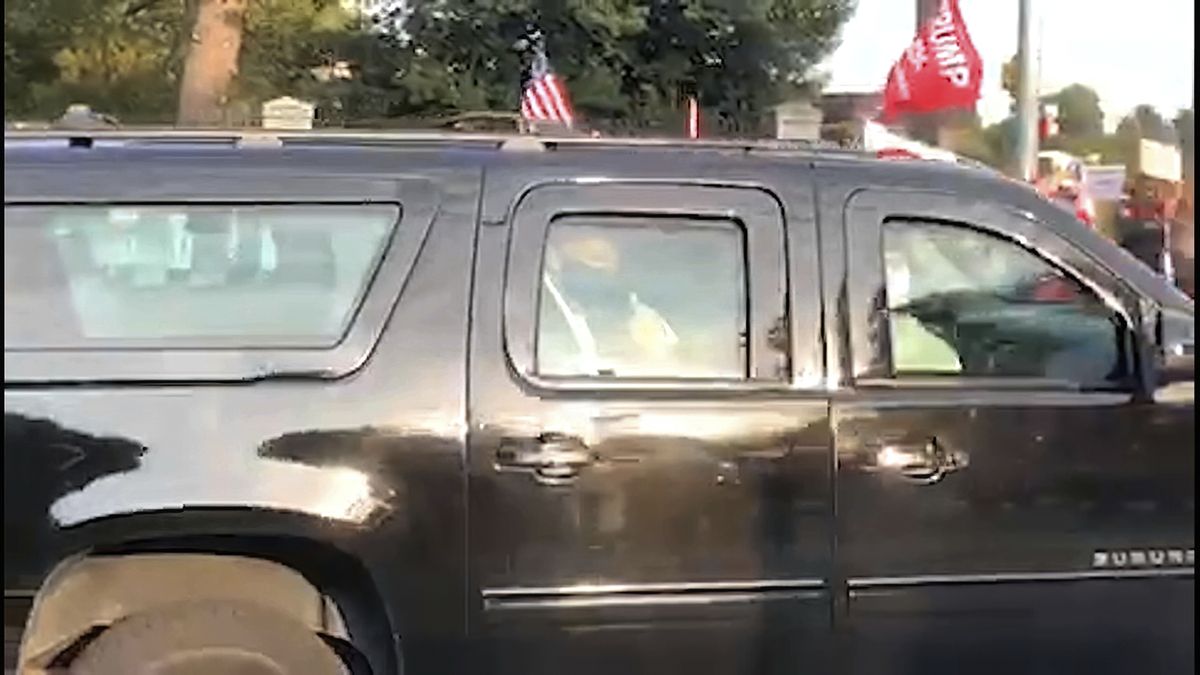 In this image from video, President Donald Trump drives past supporters gathered outside Walter Reed National Military Medical Center in Bethesda, Md., Sunday, Oct. 4, 2020. Trump was admitted to the hospital after contracting COVID-19.  (Phillip Crowther)