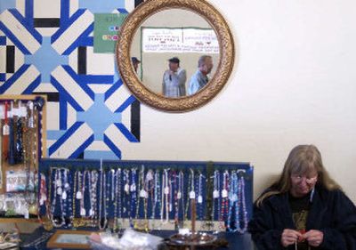 
Tamara McFarlane works on a beaded necklace at Thistledome in the Market Street Market. Thistledome, which has handmade jewelry and beads, is one of the stands in the public market in Hillyard. 
 (Photos by Liz Kishimoto/ / The Spokesman-Review)