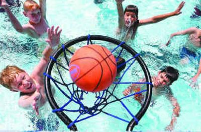 Sheldon Rassier, 9, makes a slam dunk at the Cheney pool on Friday. Almost 200 people used the pool during the 12 hours of opening day.
(Jed Conklin / The Spokesman-Review)