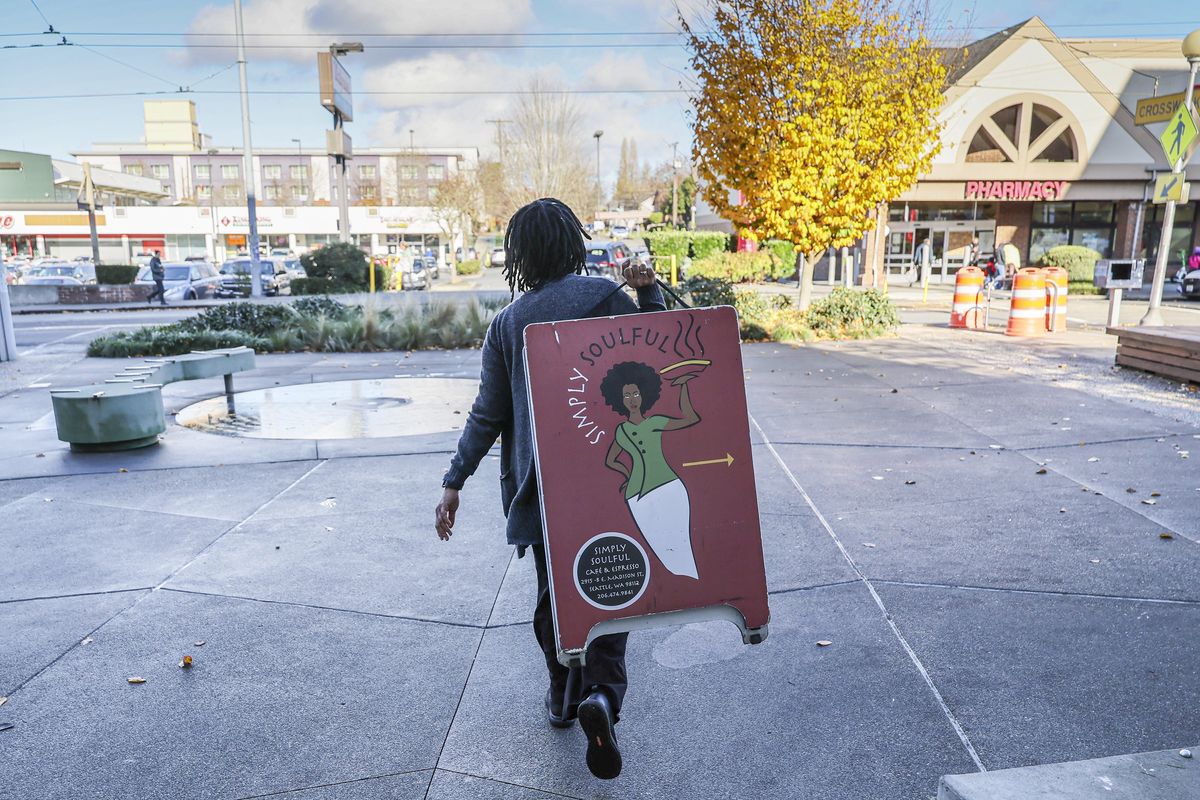 Lillian Rambus, co-owner, places the a-frame signage for Simply Soulful Thursday morning in Seattle, on Nov. 20, 2025. (Kevin Clark/The Seattle Times/TNS)