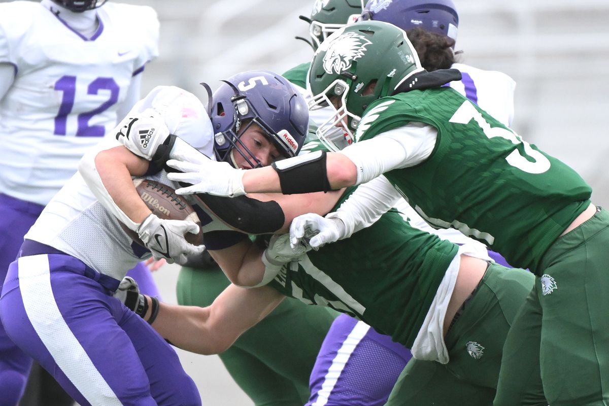 Nooksack Valley running back Skyler Whittern is stopped by Lakeside lineman Ethan Stueckle (57) and linebacker Brady Nine (34) in first half of the State 1A semifinal at Union Stadium on Sat. Nov. 25, 2023 in Spokane WA.  (James Snook)
