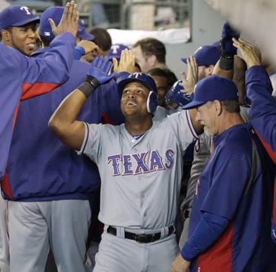 Rangers' Adrian Beltre receives high-fives for his two-run home run Sunday in Seattle. (Associated Press)