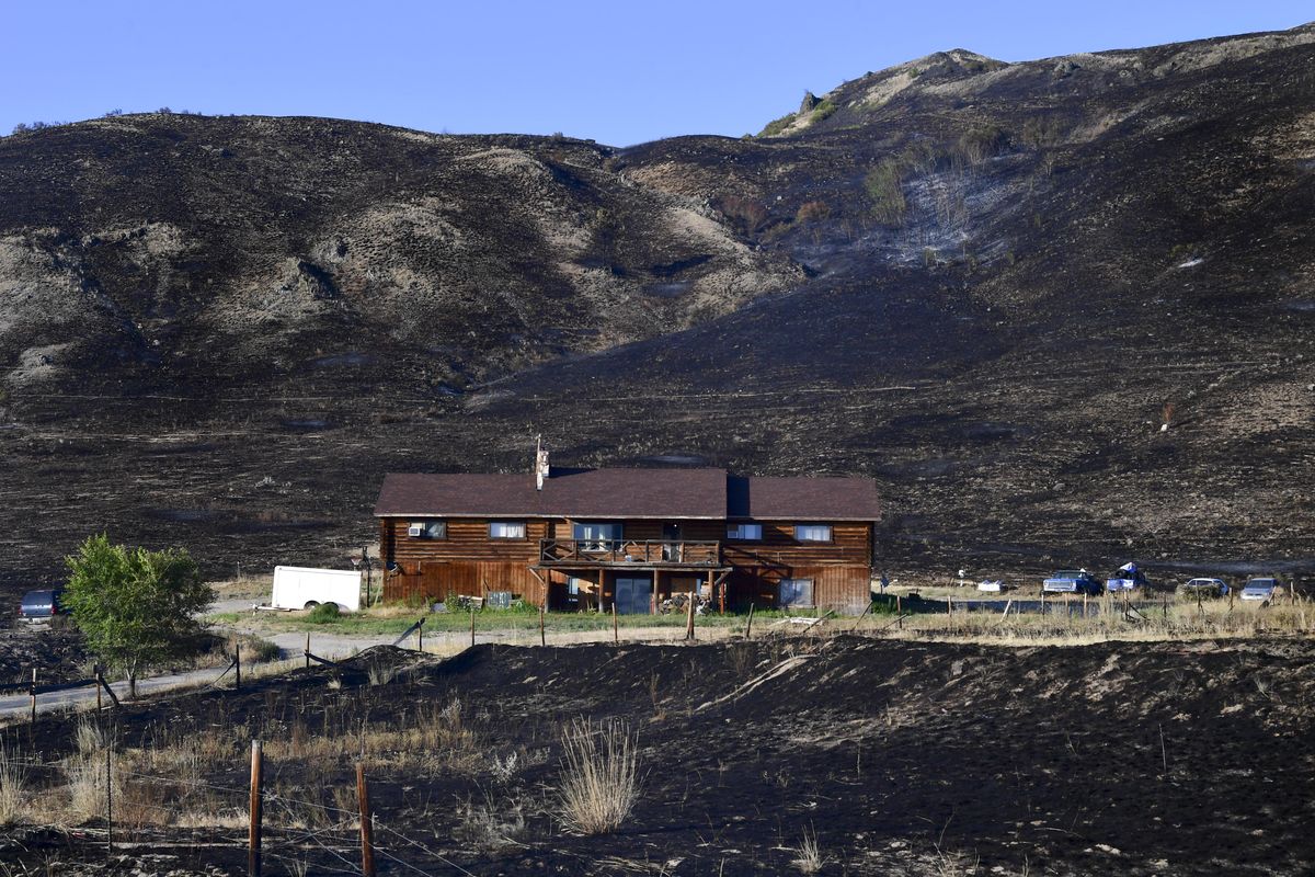 Earlier this week, crews kept the Chuweah Creek Fire from claiming this home, photographed on Friday, off State Route 155 in Nespelem, Wash.  (Tyler Tjomsland/The Spokesman-Review)