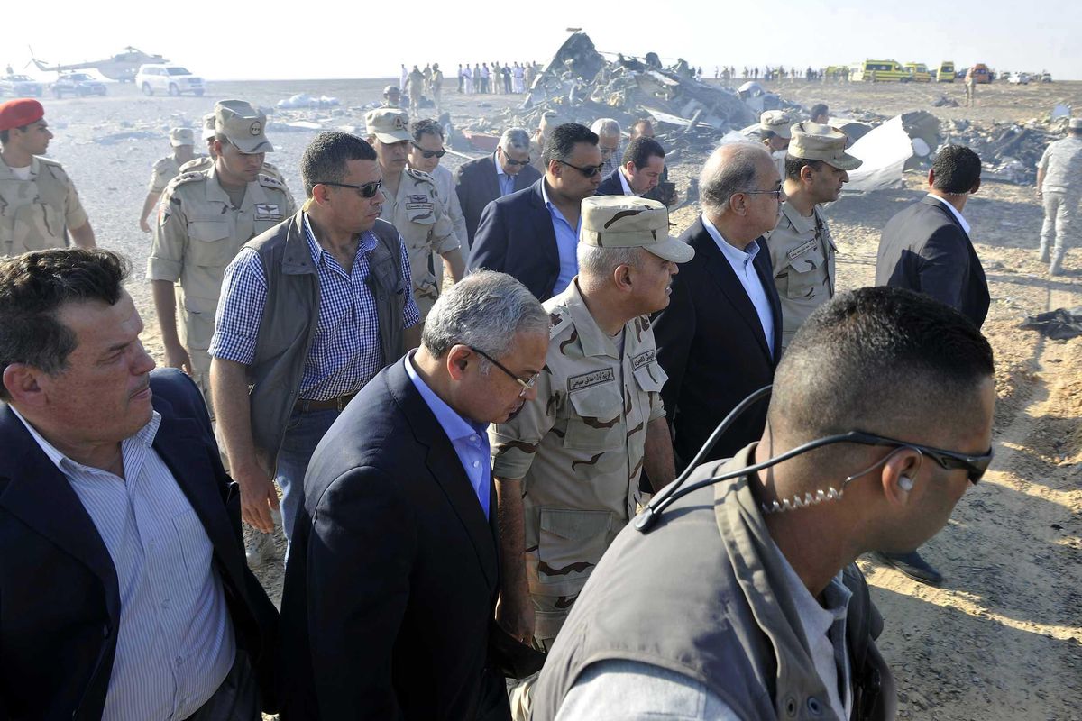 In this image released by the Prime Minister’s office, Sherif Ismail, third right, along with milirary and government officials, tour the site where a passenger plane crashed Saturday in Hassana, Egypt. (Suliman el-Oteify / Associated Press)