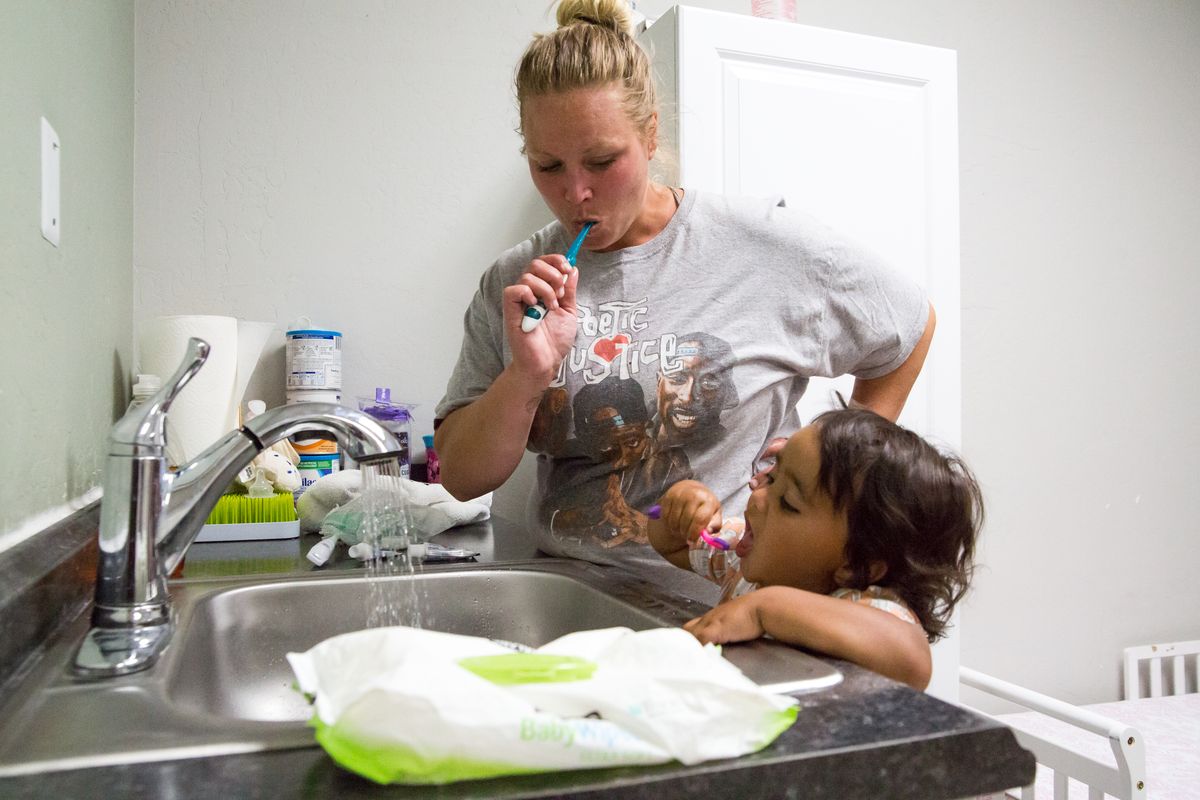 Dawn McKnight brushes her teeth with her daughter Bella McKnight, age 2, while the evening winds down before lights-out in the Family Promise of Spokane shelter on Aug. 11, 2020. The low-barrier emergency shelter has the capacity for 60 guests and accepts all family models, except for single adults, with the goal to "exit to permanent housing" driving its practices. Intake of new families includes a one-week quarantine due to COVID, but each family