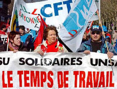 
People demonstrate in Bayonne, southwestern France, earlier this month, to defend the 35-hour workweek and to push for more jobs and pay talks. Introduced under the Socialists but headed for effective abolition by lawmakers today, 