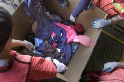 
Workers pile discarded Bloomsday clothes into boxes Monday. The race     attracts at least 40,000 runners annually, and many toss warmups into the trees along the first few blocks of the race. 
 (Christopher Anderson / The Spokesman-Review)