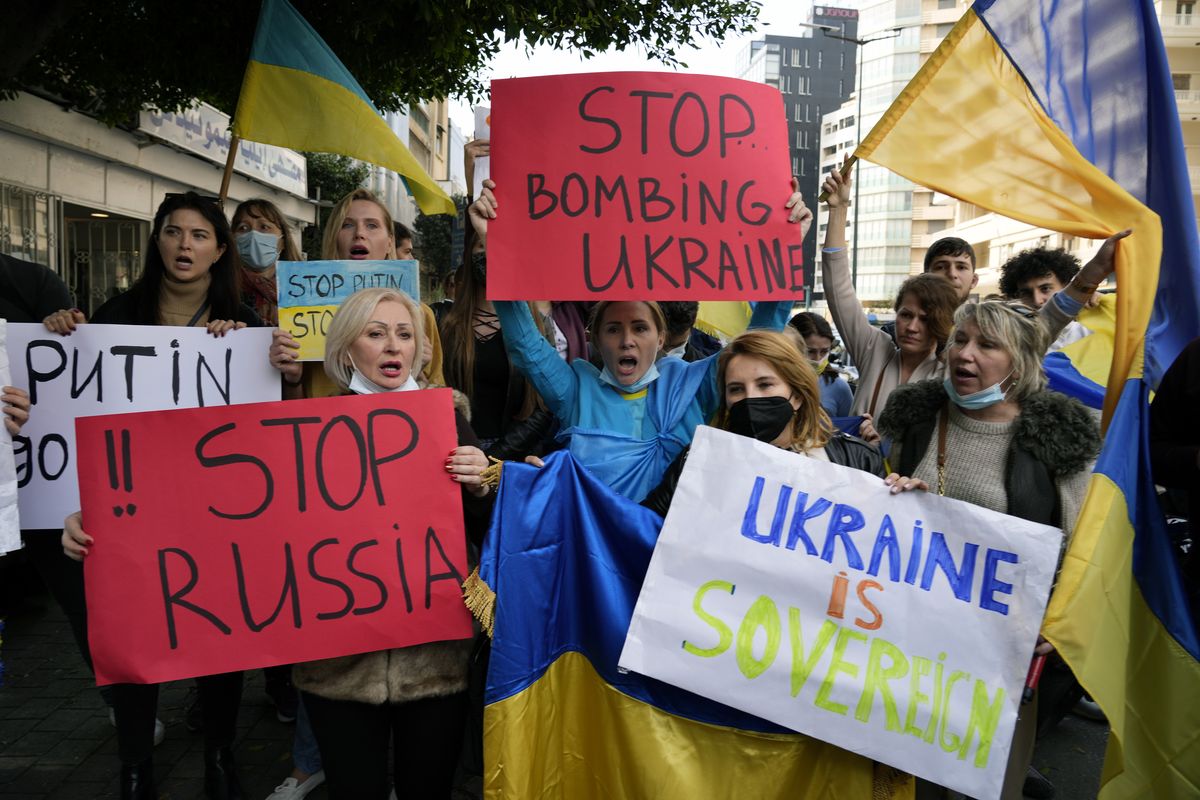 Ukrainians who live in Lebanon holds placards and chant slogans during a protest against Moscow