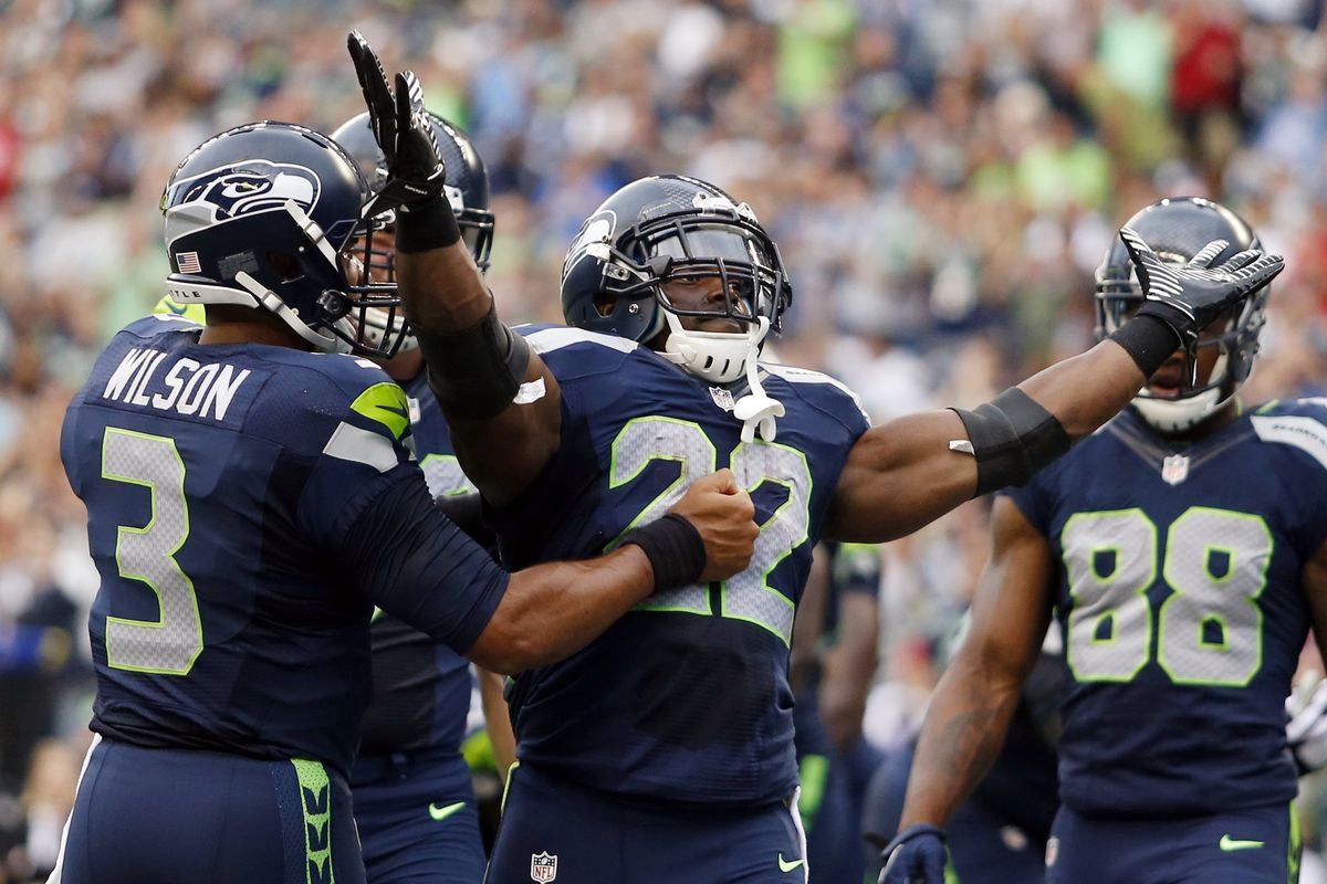 Seahawks quarterback Russell Wilson, left, congratulates Robert Turbin after the running back bulled in for a 1-yard touchdown run. (Associated Press)