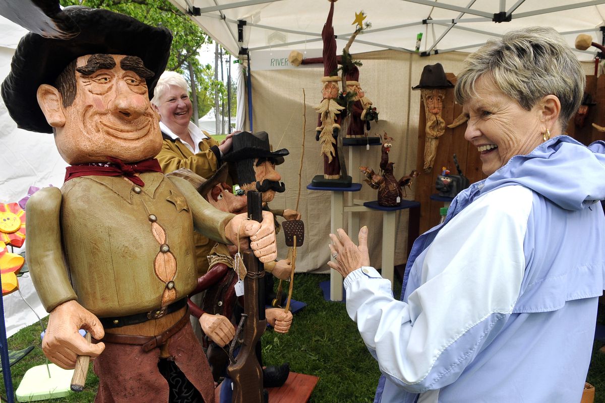 Vivian Zagelow, right, 69, of Spokane , gets a chuckle from viewing driftwood art titled “Sheriff Nub,” by Monica Archer, left, and her husband, Dale, of Heron, Mont., during ArtFest on Friday in Coeur d’Alene Park in Spokane’s Browne’s Addition. The driftwood is found near the Archers’ home and it takes 4-8 weeks to create their pieces. (DAN PELLE PHOTOS)