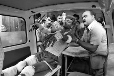 
People help carry an injured man as he is brought to a hospital for treatment after a bomb explosion in Gauhati, India, on Saturday. 
 (Associated Press / The Spokesman-Review)