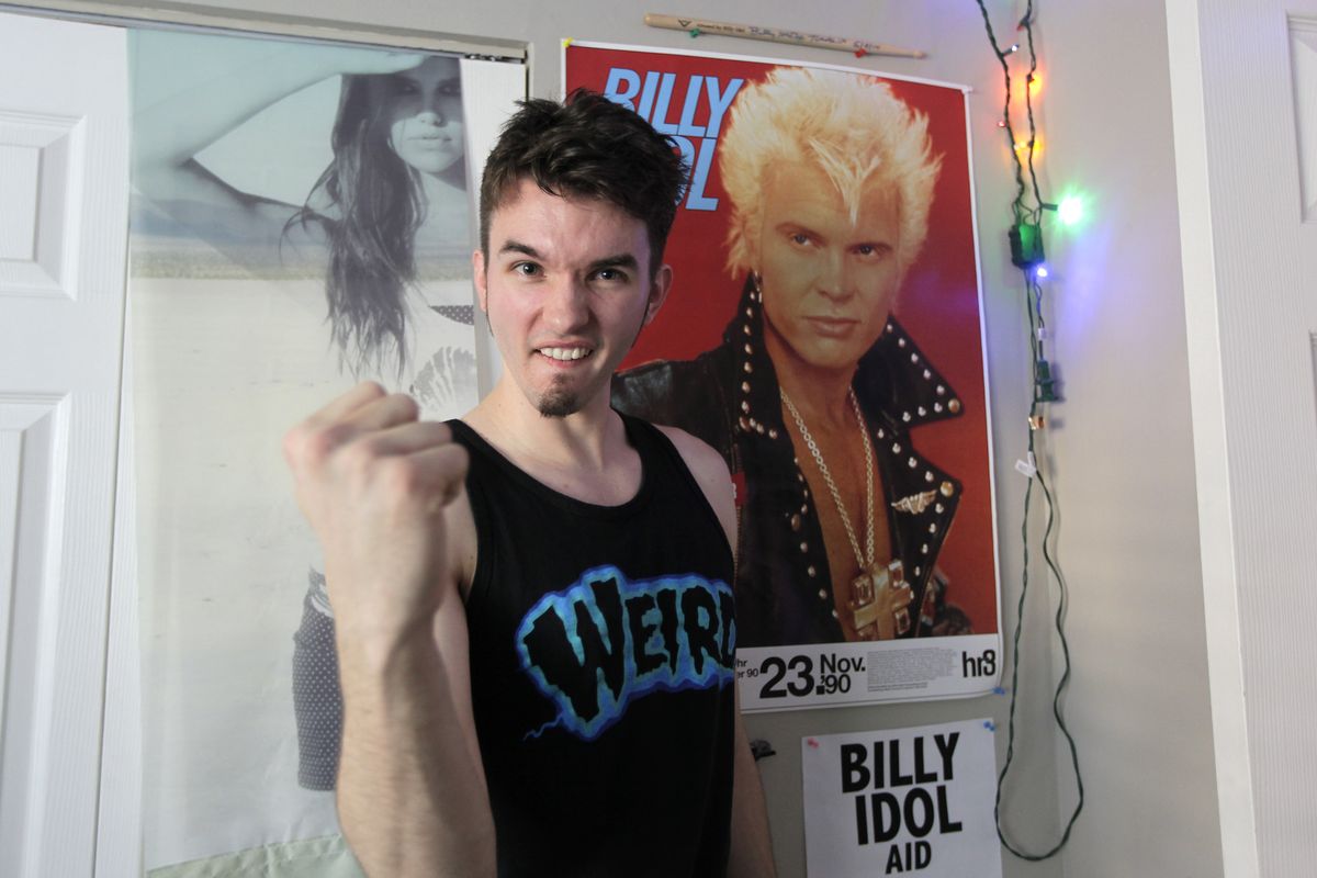 Michael Henrichsen poses for a photo, Sept. 19, 2012 in his bedroom at his home in Seattle next to a poster of rock star Billy Idol. Henrichsen created a website and enlisted friends and celebrities around the world in a two-year effort to convince Idol to come play a concert on Oct. 26, 2012 at a Seattle music venue to raise money for charity and celebrate Henrichsen