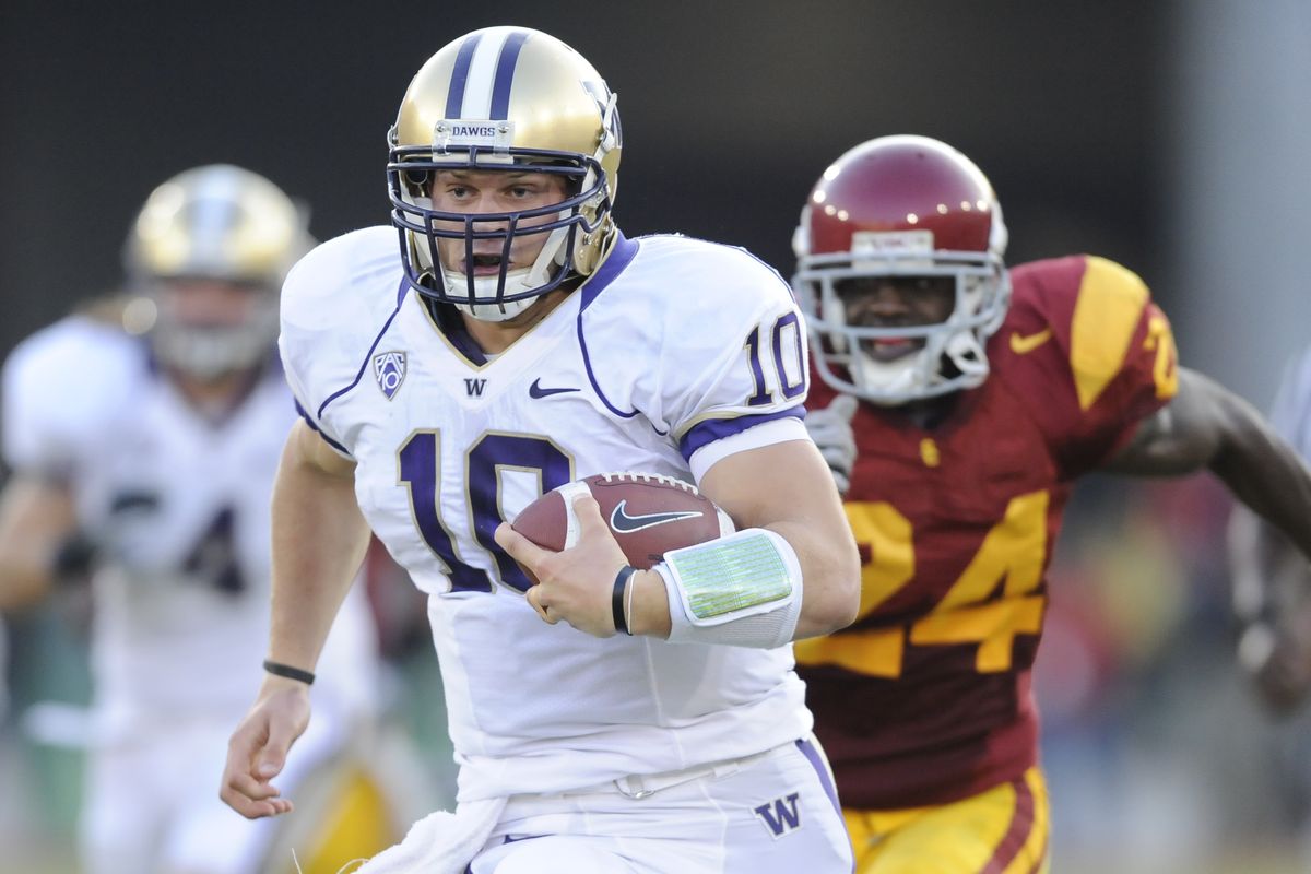 Washington quarterback Jake Locker runs with the ball as USC’s Shareece Wright gives chase. (Associated Press)