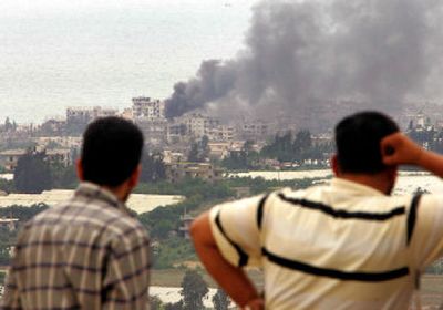 
 Lebanese men watch  smoke billow from a site of  shelling at the Palestinian refugee camp of Nahr el-Bared  on Friday. 
 (Associated Press / The Spokesman-Review)