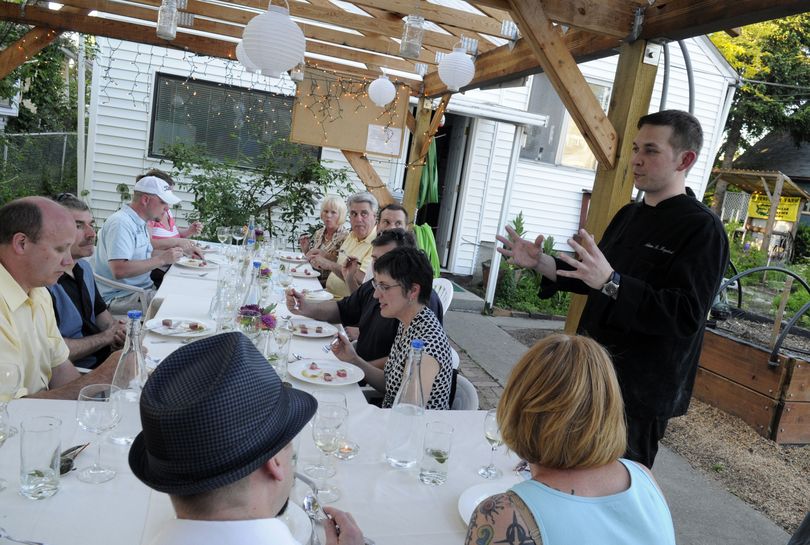 Chef Adam Hegsted explains to his guests at The Wandering Table his philosophy that “gets people excited about food and community.” His “nomadic chef’s table” 10-course meal was held in the backyard garden of Riverfront Farm in the West Central neighborhood.  (J. BART RAYNIAK)