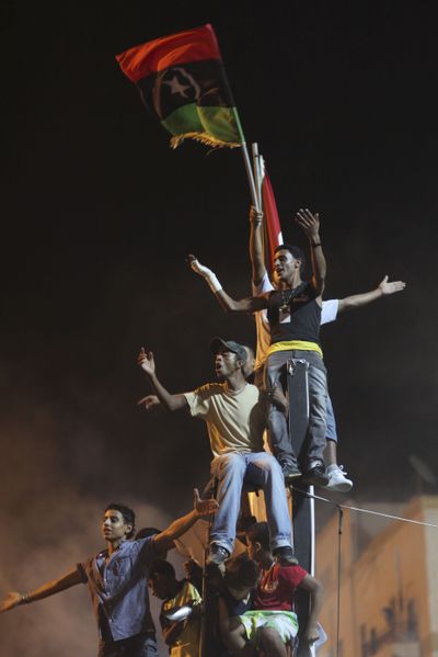 People celebrate the news of uprising in Tripoli against Moammar Gadhafi’s regime at the rebel-held town of Benghazi, Libya, early today. (Associated Press)