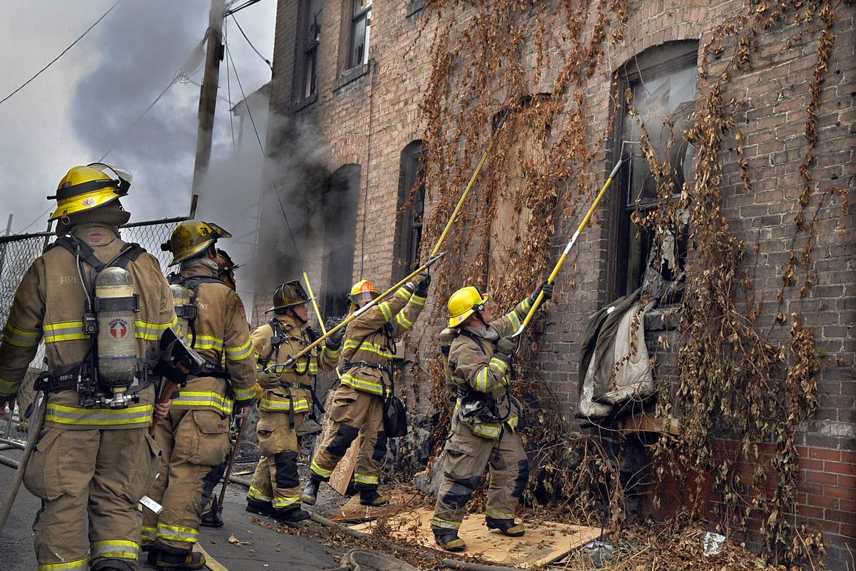 Fire crews extinguish a fire Thursday morning at State Street Flats, 168 S. State St., where two people were arrested and five others could face charges. Authorities are conducting an arson investigation. (Christopher Anderson / The Spokesman-Review)