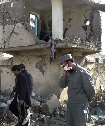 An Afghan police officer wounded in a blast, is seen as he walks at the site of a suicide attack in Khost province on Sunday.  (Associated Press / The Spokesman-Review)