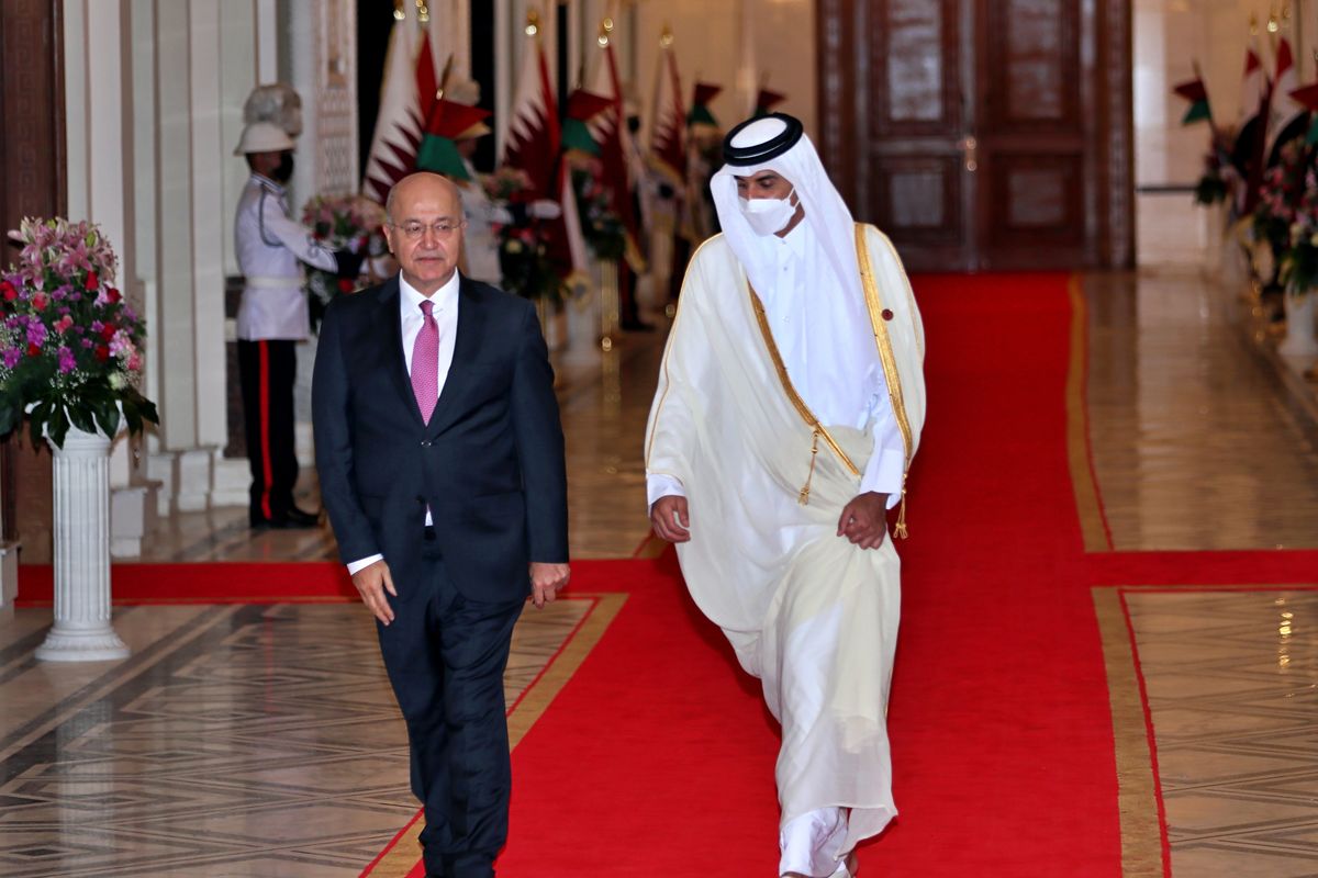 Iraqi President Barham Salih, left, welcomes Qatar