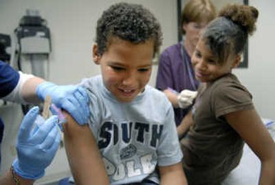 
Robert Rucker, 10, and his sister Mercedes, 11, receive immunizations last week during a visit to the Community Health Association of Spokane clinic, located in the Northeast Community Center. 
 (Photos by DAN PELLE / The Spokesman-Review)