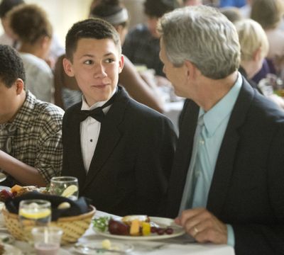 Special occasion: Holmes Elementary School sixth-grader Noah Wilson wears a tuxedo during the school’s sixth annual Dining at the Ritz on Wednesday in Spokane. Some 50 students from two sixth-grade classes, many wearing ties or dresses, were served a formal meal in the lunchroom where they learned dining etiquette and the importance of self-confidence in formal settings. Noah shares conversation during his meal of lasagna, fruit kabob and white chocolate cake with Holmes Principal Steve Barnes. (Dan Pelle)