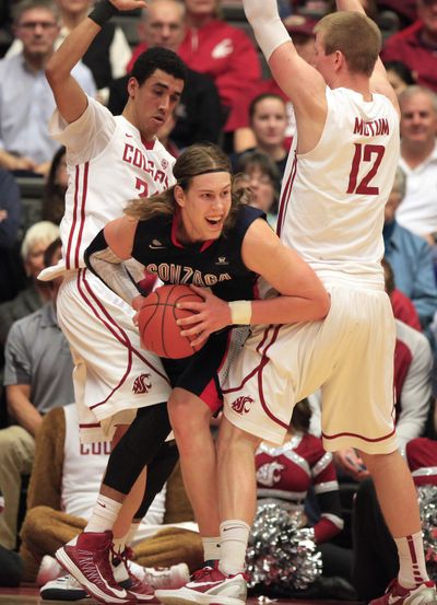 Gonzaga forward Kelly Olynyk, center, drives between Washington State guard Dexter Kernich-Drew, left, and forward Brock Motum (12) after grabbing a rebound during the second half of an NCAA college basketball game Wednesday at Beasley Coliseum in Pullman. Gonzaga won 71-69. (Dean Hare / Associated Press)