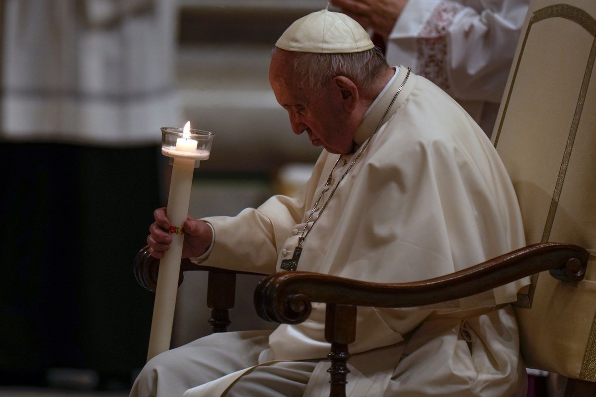 Pope Francis holds a Paschal candle as he presides over a Easter vigil ceremony at St. Peter