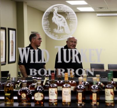 Master Distiller Jimmy Russell, right, and his son Eddie are reflected in a mirror in the Wild Turkey Distillery offices in Lawrenceburg, Ky. (Associated Press)