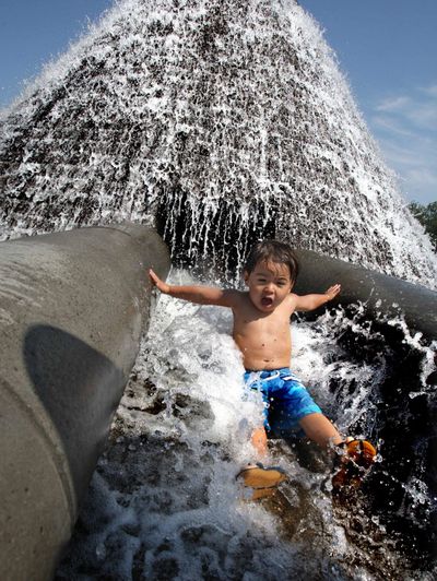 Benicio Gonzales, 3, slides down the spillway on the water feature at Cal Anderson Park in Seattle on Thursday, July 30, 2009. Temperatures in the Pacific cooled a bit Thursday after hitting the triple digits Wednesday. (Steve Ringman / The Seattle Times)