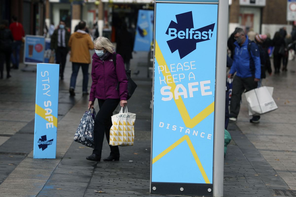 A woman wears a face mask in Belfast city centre, Northern Ireland, Wednesday, Oct. 14, 2020. Northern Ireland introducing the tightest COVID-19 restrictions in the United Kingdom on Wednesday, closing schools for two weeks and pubs and restaurants for a month. “This is not the time for trite political points," First Minister Arlene Foster told lawmakers at the regional assembly in Belfast. “This is the time for solutions." (Brian Lawless)