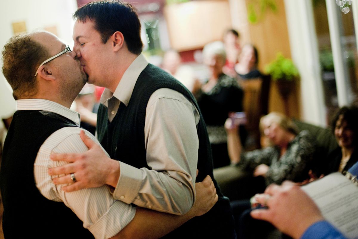 Chris Henry, left, and Chase Lawrence embrace and kiss during their wedding ceremony in front of friends early Sunday morning at a friend’s home near Medical Lake. (Tyler Tjomsland)