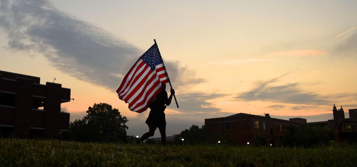 Before sunrise University of Tennessee at Chattanooga ROTC Graduate Student Trevon Wiggins jogs as he carries the American Flag around Chamberlain Field. From 6 a.m. until 5:00, on Sept. 11, 2019, the American Flag, carried by members of the Military Science Department at the University of Tennessee at Chattanooga, students and staff, continuously circled Chamberlain Field on the University