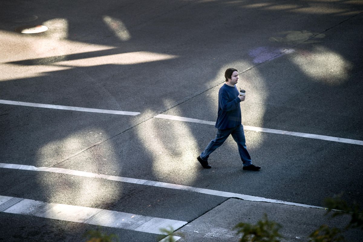 A pedestrian crosses Riverside Avenue at Wall Street, Oct. 1, 2017, in downtown Spokane, Wash. (Dan Pelle / The Spokesman-Review)