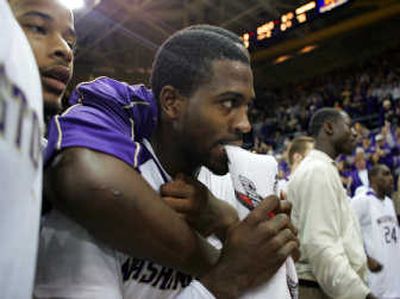 
Washington's Justin Dentmon bites on a towel as he awaits the referees' instant replay review. Associated Press
 (Associated Press / The Spokesman-Review)