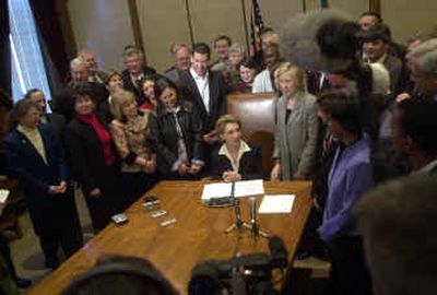 
Gov. Christine Gregoire, center, prepares to sign into law the first two bills of her administration Thursday in Olympia.
 (Associated Press / The Spokesman-Review)