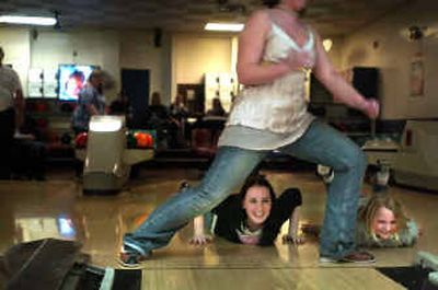 
Dennielle Felton, 16, celebrates with Victoria Keith, 9, (right) after she bowled between the legs of Crystal Williams, 15, at Colonial Bowl last Thursday. One of Spokane's North Side landmarks, Colonial Bowl, situated on the corner of Ruby and Sharp, will be closing its doors forever on March 18. 
 (Jed Conklin / The Spokesman-Review)
