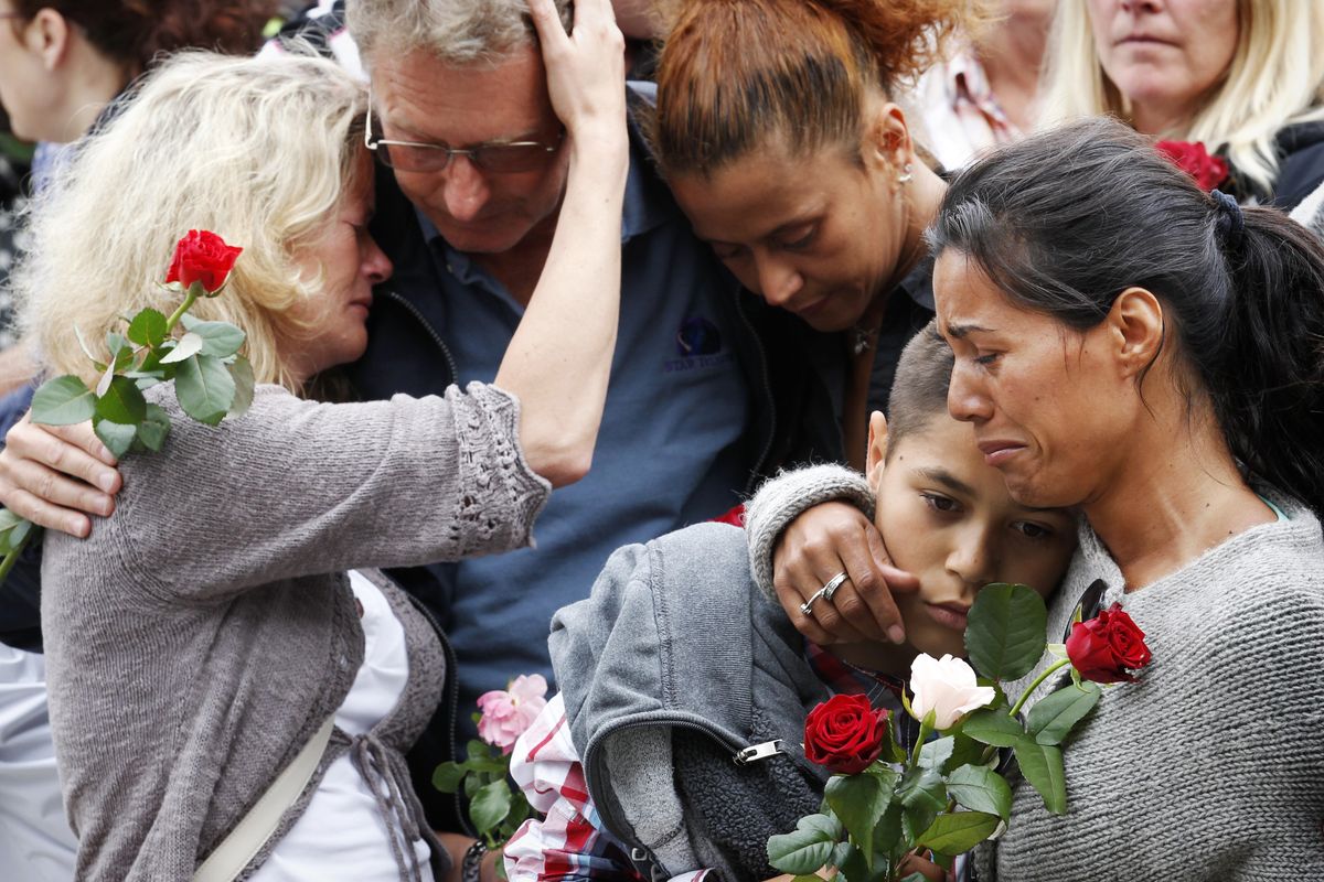 People comfort each other outside Oslo City Hall on Monday as they participate in a rose march in memory of the victims of Friday’s bomb attack and shooting massacre. (Associated Press)