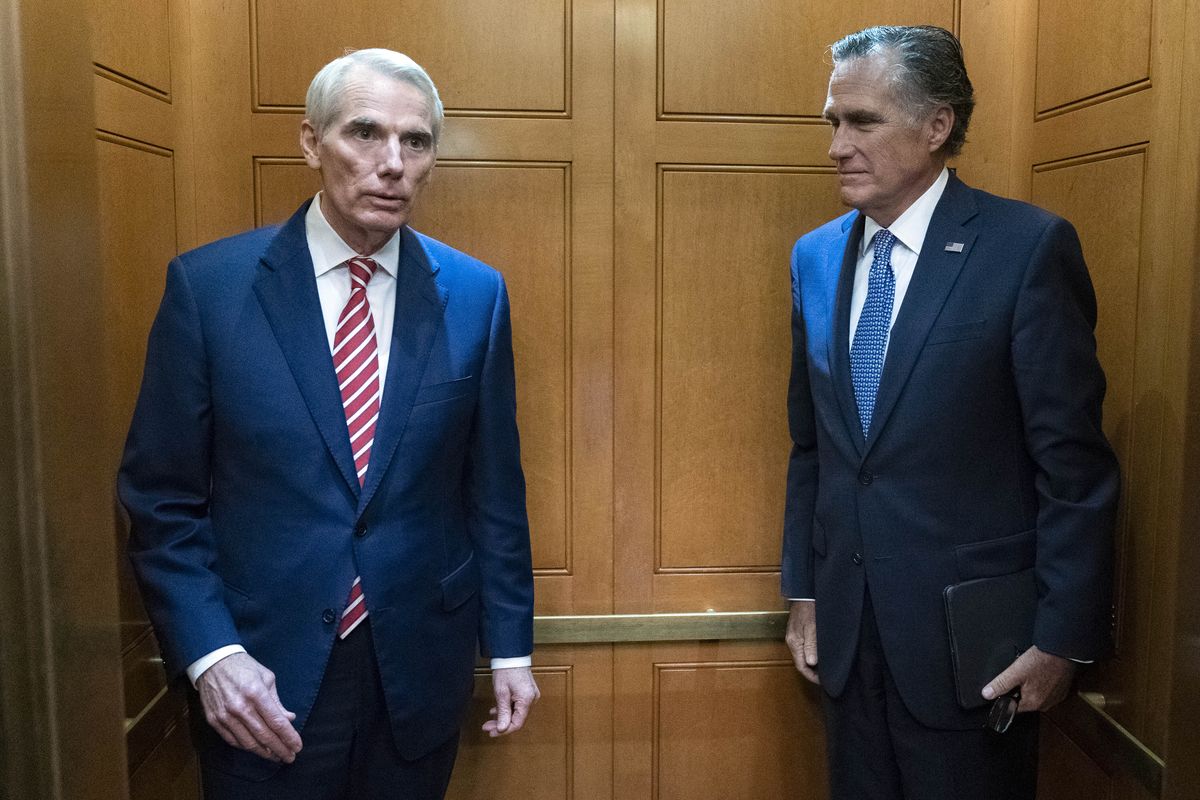 Sen. Rob Portman, R-Ohio, left, accompanied by Sen. Mitt Romney, R-Utah, leave in the elevator after a closed door talks about infrastructure on Capitol Hill in Washington Thursday, July 15, 2021.  (Jose Luis Magana)