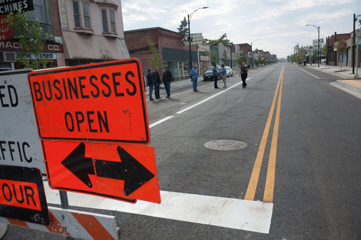 Local business owners and politicians gather on East Sprague Avenue during an informal ceremony to remove construction barricades  between Helena and Napa streets on Friday, September 15, 2017, in Spokane. (Tyler Tjomsland / The Spokesman-Review)