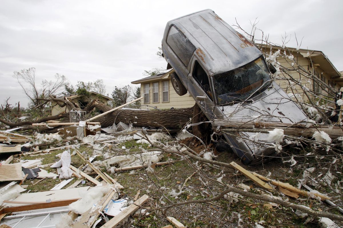 A vehicle rests on a tree after an overnight tornado in Tushka, Okla., on Friday. (Associated Press)