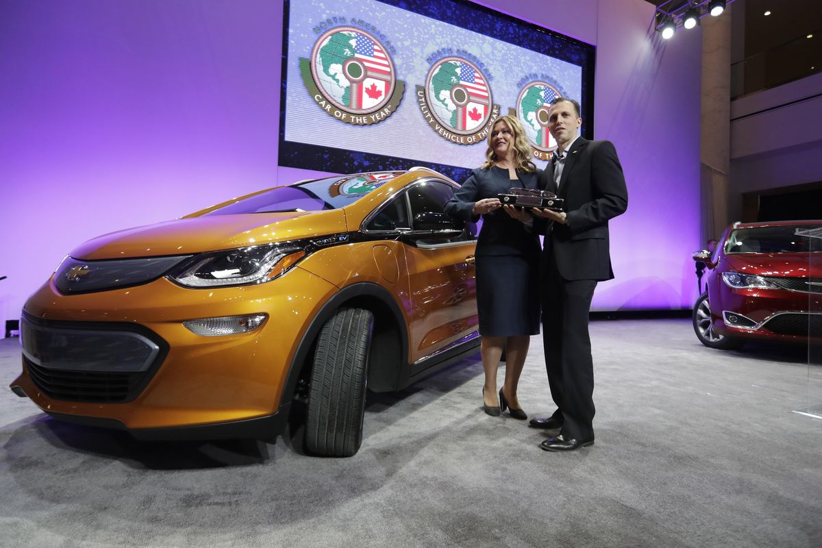 General Motors Executive Chief Engineer Autonomous & Electrified Vehicles and New Technology Pam Fletcher, left, and Bolt Chief Engineer Josh Tavel stand next to a Chevy Bolt after being named top car in the North America at the North American International Auto show on Monday in Detroit. (Carlos Osorio / AP)
