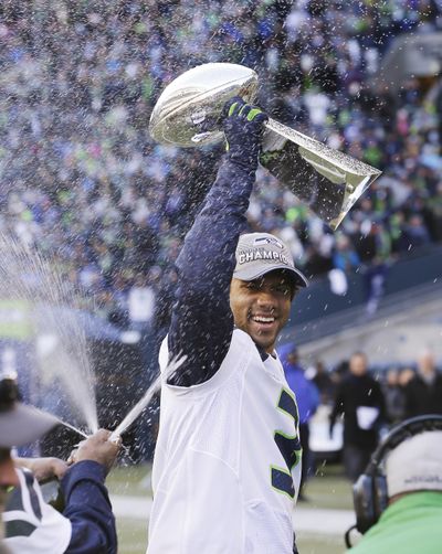 Seattle Seahawks’ Russell Wilson celebrates with the Vince Lombardi Trophy at a rally for the NFL football Super Bowl champions in Seattle. Russell Wilson would be playing for the Philadelphia Eagles if Andy Reid got his man in 2012. Reid planned to select Wilson in the third round of the NFL draft that year, but Seahawks general manager John Schneider beat him to it. (Elaine Thompson / Associated Press)
