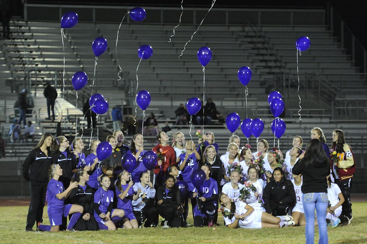 The members of the Rogers Pirates and University Titans soccer teams release helium balloons while cameras snap photos before their GSL league match Wednesday at University High School. The sign of friendship, balloons and flowers from Rogers players were offered in honor of the two U-Hi teens, Josie Freier and McKenzie Mott, who died in a car crash on Oct. 5. (Jesse Tinsley)