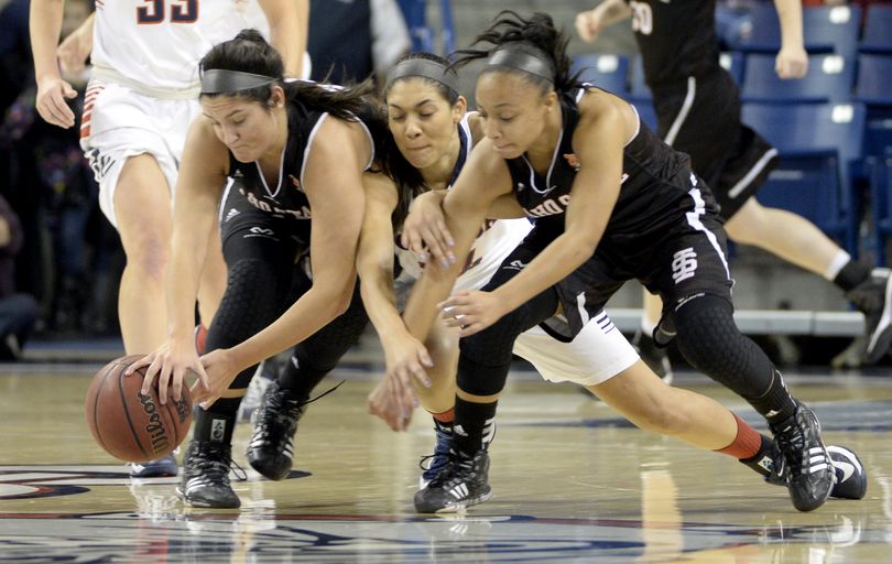 Gonzaga's Keani Albeniz, center, dives for the loose ball between Idaho State's Rebecca Schrimpsher, left, and Jasmine Lemon, right, and gets called for the foul Tuesday, Nov. 18, 2014 at the McCarthey Athletic Center. At the half, the Lady Zags were up 41-40. (Jesse Tinsley / The Spokesman-Review)