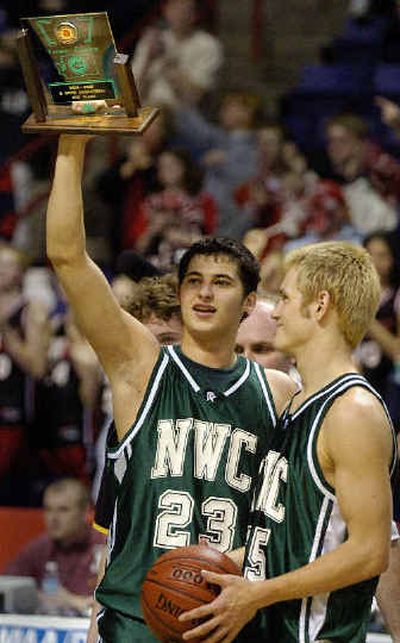 
Northwest Christian's Jesse Vowels holds up the third-place trophy as teammate Josh Greer looks on. 
 (Christopher Anderson/ / The Spokesman-Review)