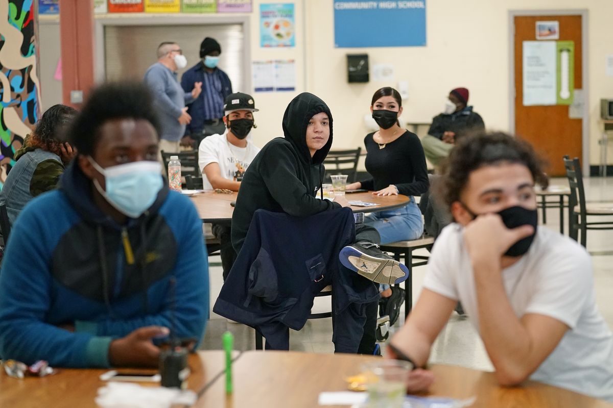 In this Oct. 29, 2020 photo, students at West Brooklyn Community High School listen to questions posed by their principal during a current events-trivia quiz and pizza party in the school